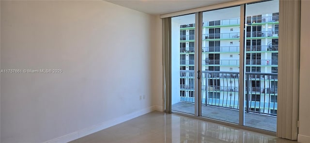 unfurnished room with a wall of windows and baseboards