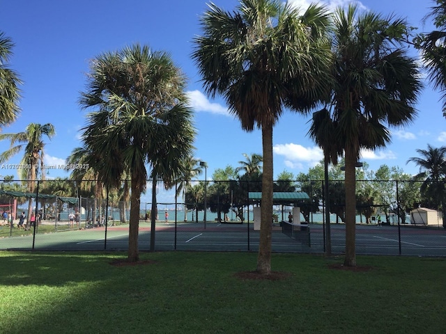 view of sport court with a yard and fence