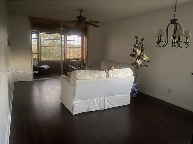 unfurnished living room featuring dark wood finished floors, ceiling fan, and baseboards