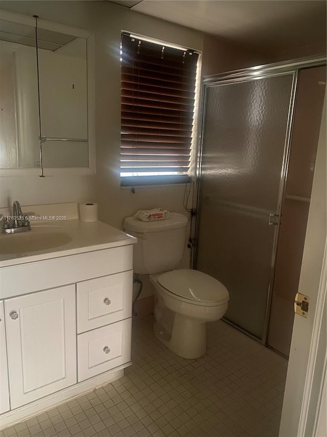 full bath with a shower stall, vanity, and toilet