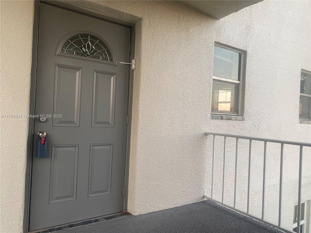 entrance to property featuring stucco siding