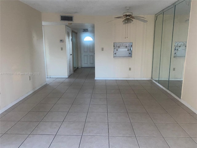 unfurnished room with a ceiling fan, baseboards, and visible vents