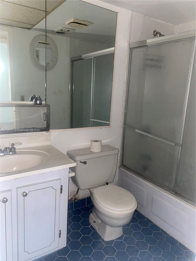 bathroom featuring toilet, vanity, and bath / shower combo with glass door