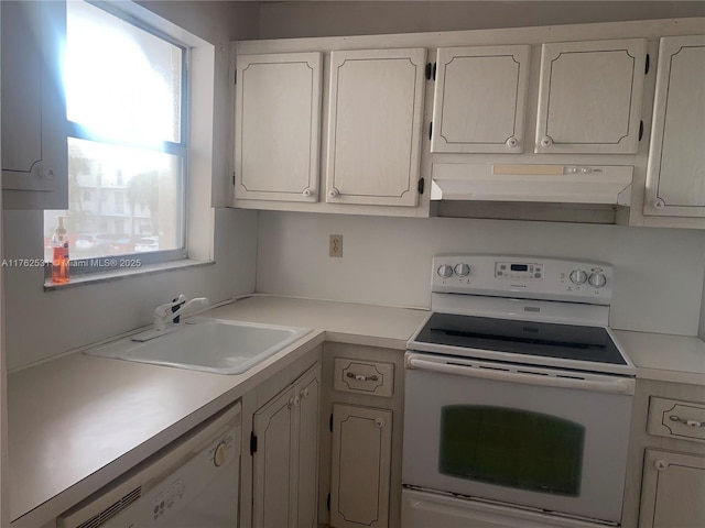 kitchen with under cabinet range hood, white appliances, light countertops, and a sink