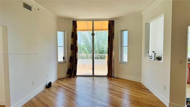 unfurnished room featuring visible vents, baseboards, crown molding, and light wood-style floors