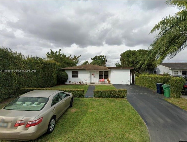 ranch-style house featuring a front yard and driveway