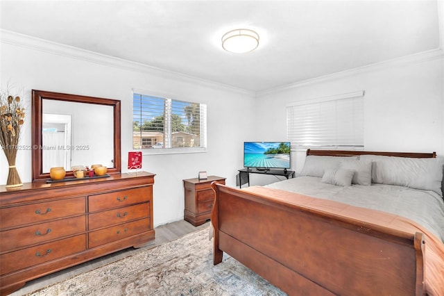 bedroom with crown molding and light wood-style flooring