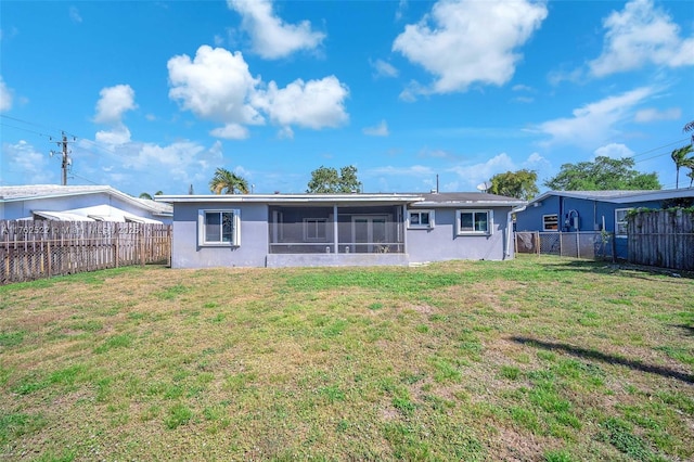 back of property with a yard, a fenced backyard, and a sunroom