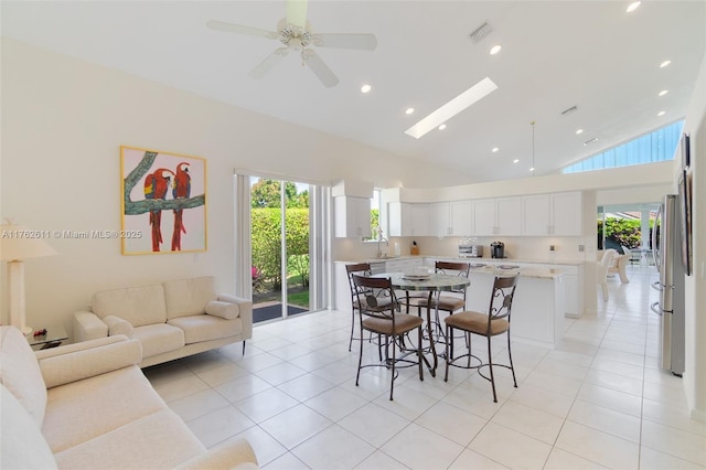 dining area featuring visible vents, light tile patterned floors, recessed lighting, a skylight, and high vaulted ceiling