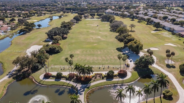 drone / aerial view with golf course view and a water view