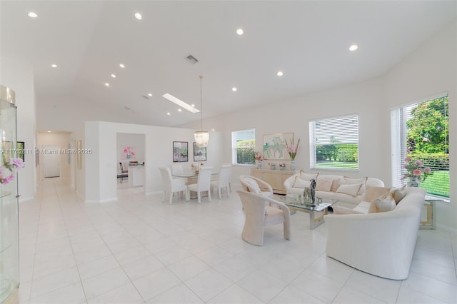 living area featuring light tile patterned floors, visible vents, recessed lighting, and high vaulted ceiling