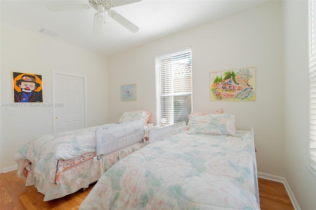 bedroom with visible vents, ceiling fan, baseboards, and wood finished floors