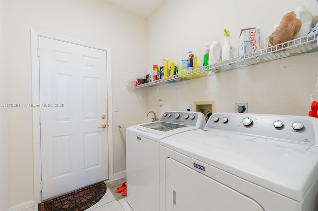 laundry room with washer and clothes dryer, laundry area, and light tile patterned floors