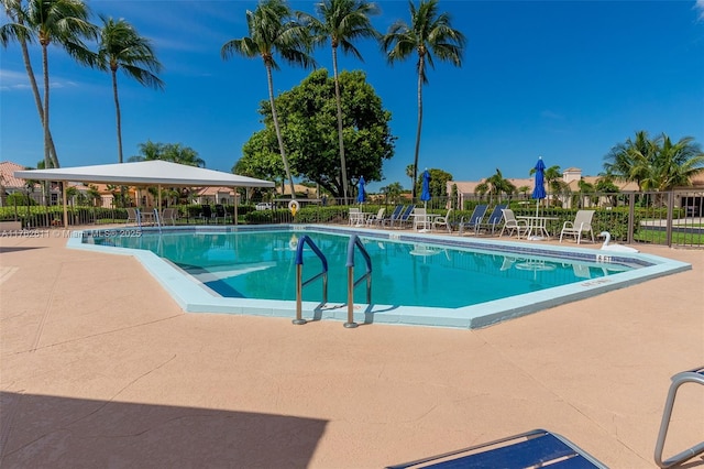 community pool featuring a patio and fence