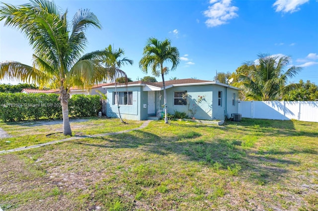 rear view of property with fence, central AC, stucco siding, a lawn, and a gate