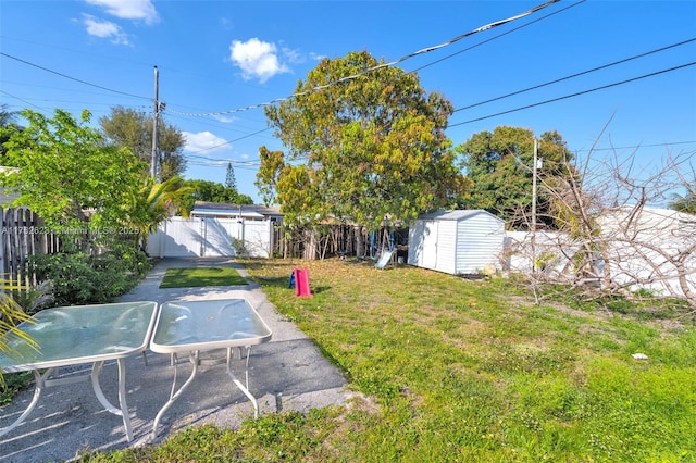 view of yard with an outdoor structure, a fenced backyard, and a shed