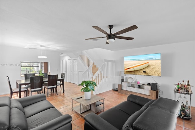 living room featuring ceiling fan, stairs, and tile patterned flooring