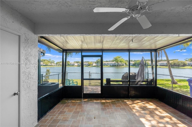 unfurnished sunroom featuring a water view and ceiling fan