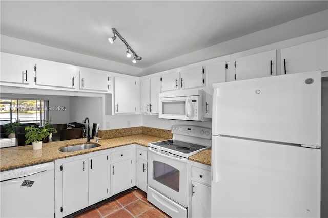 kitchen featuring white appliances, light stone counters, a sink, track lighting, and white cabinets