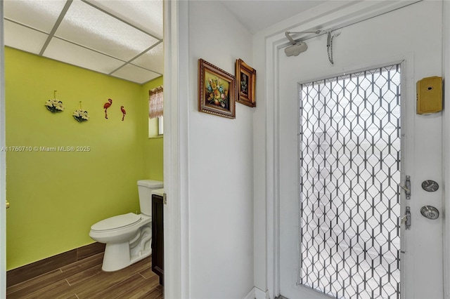 bathroom featuring a drop ceiling, toilet, and wood finished floors