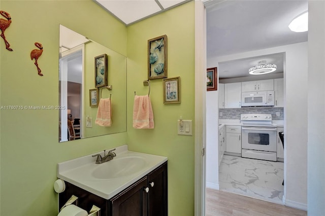 bathroom featuring vanity, tasteful backsplash, baseboards, and marble finish floor