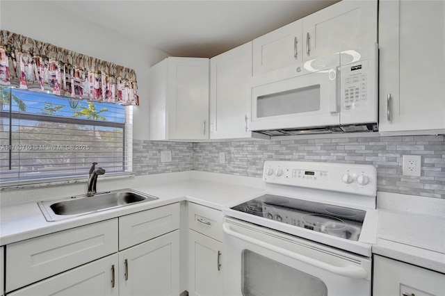 kitchen with backsplash, light countertops, white appliances, white cabinetry, and a sink