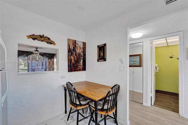 dining room with visible vents, baseboards, and light wood-style flooring