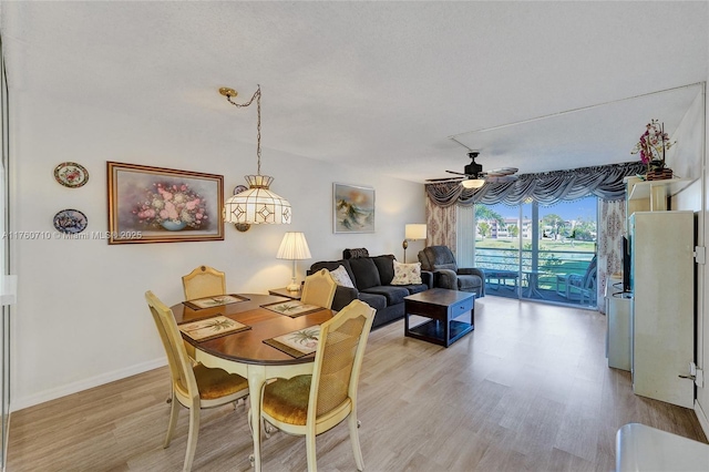 dining area with light wood-style floors, baseboards, and ceiling fan