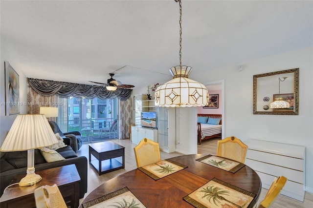 dining area with a ceiling fan and wood finished floors