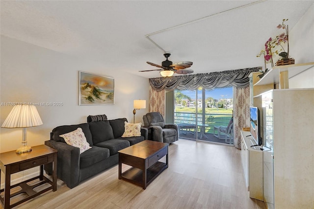 living area with light wood-type flooring and ceiling fan