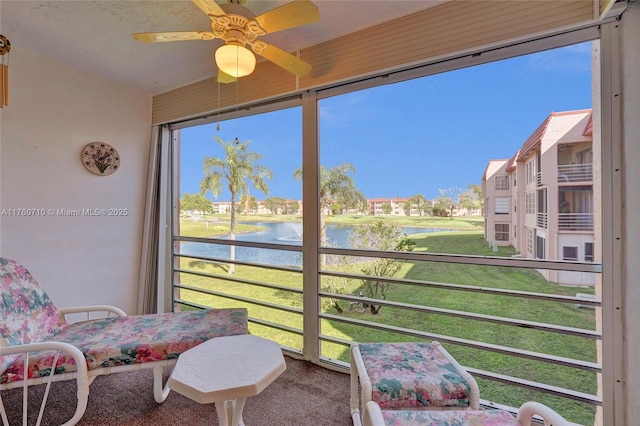 sunroom with a water view, a healthy amount of sunlight, and ceiling fan