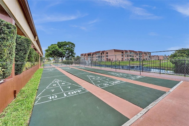 view of property's community featuring a residential view, shuffleboard, and fence