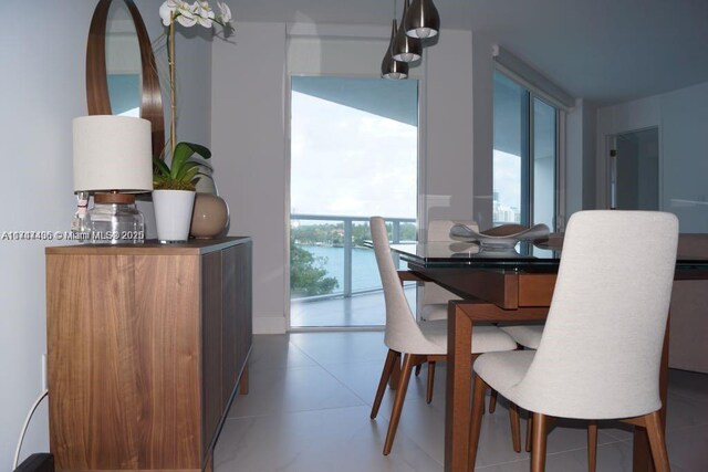 tiled dining room featuring a water view