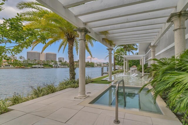 view of patio / terrace featuring a pergola, a hot tub, and a water view