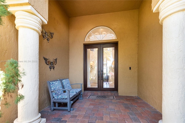 doorway to property featuring stucco siding and french doors