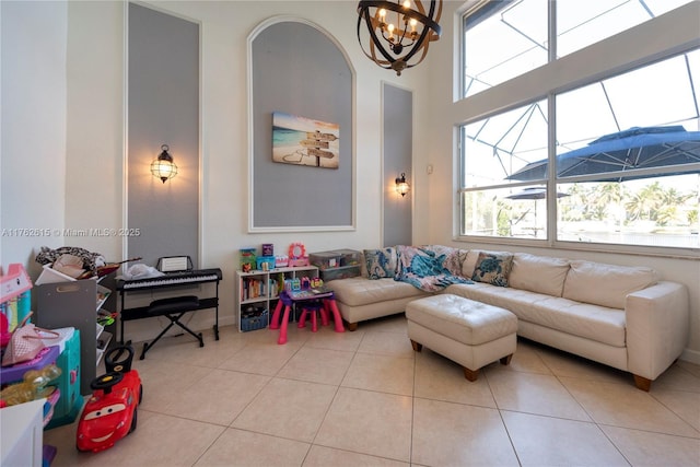 living room with light tile patterned floors, a chandelier, and a high ceiling