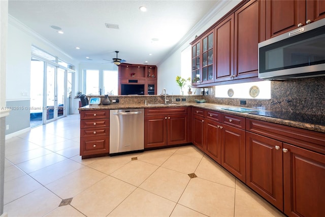 kitchen with visible vents, a peninsula, a sink, appliances with stainless steel finishes, and crown molding