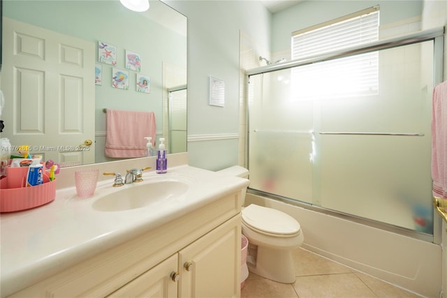 full bathroom featuring tile patterned floors, vanity, combined bath / shower with glass door, and toilet