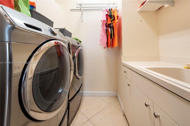 washroom featuring light tile patterned floors, washer and dryer, baseboards, and a sink