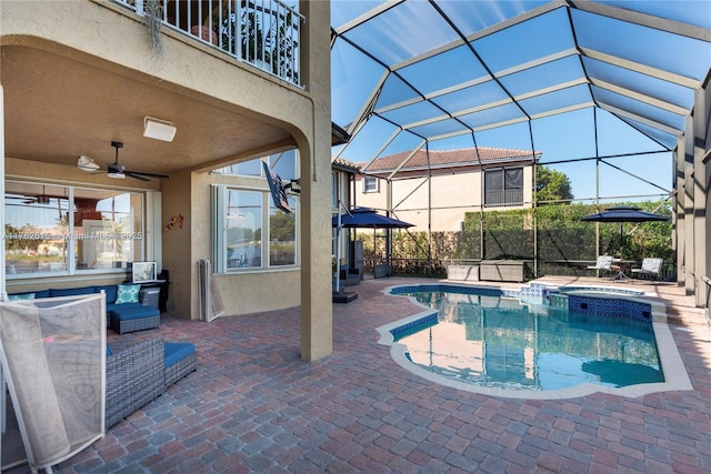 view of pool featuring a lanai, a pool with connected hot tub, a ceiling fan, and a patio