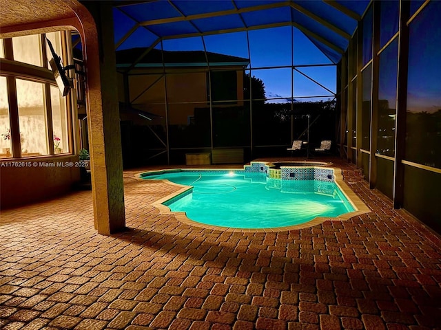 view of swimming pool featuring a lanai, a pool with connected hot tub, and a patio