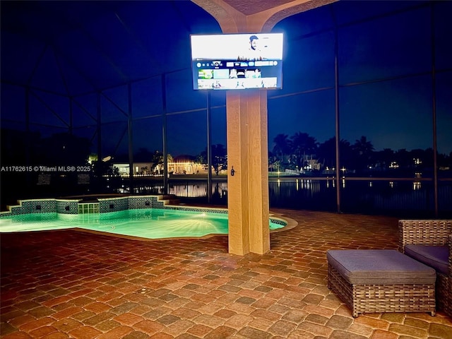 pool at night with an outdoor pool and a patio area