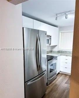 kitchen featuring track lighting, dark wood-style floors, white cabinetry, appliances with stainless steel finishes, and light countertops