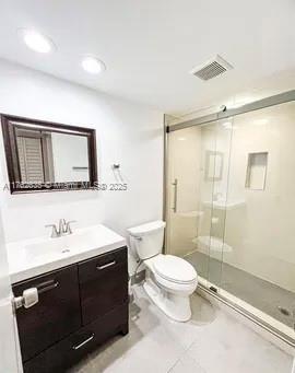 full bath featuring vanity, visible vents, a stall shower, tile patterned floors, and toilet