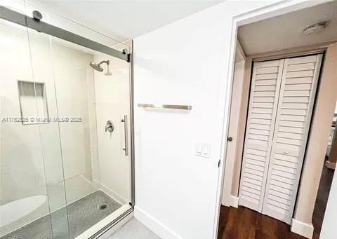 bathroom featuring baseboards and a stall shower