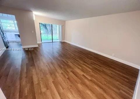 interior space with baseboards and dark wood-style floors