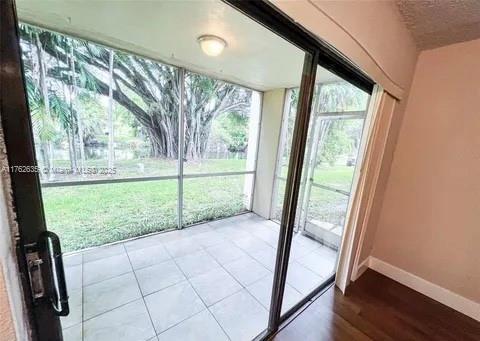 doorway with a wall of windows and baseboards