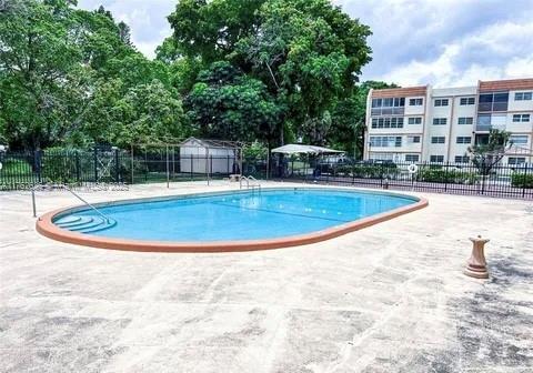 community pool with a patio and fence