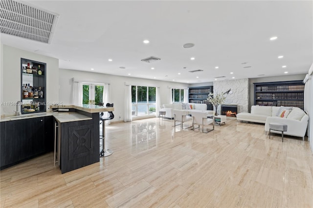 living area with recessed lighting, visible vents, and a large fireplace