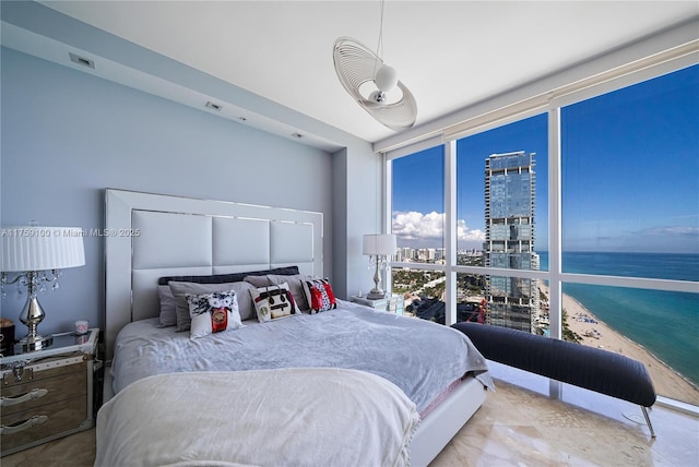 bedroom with expansive windows and a water view